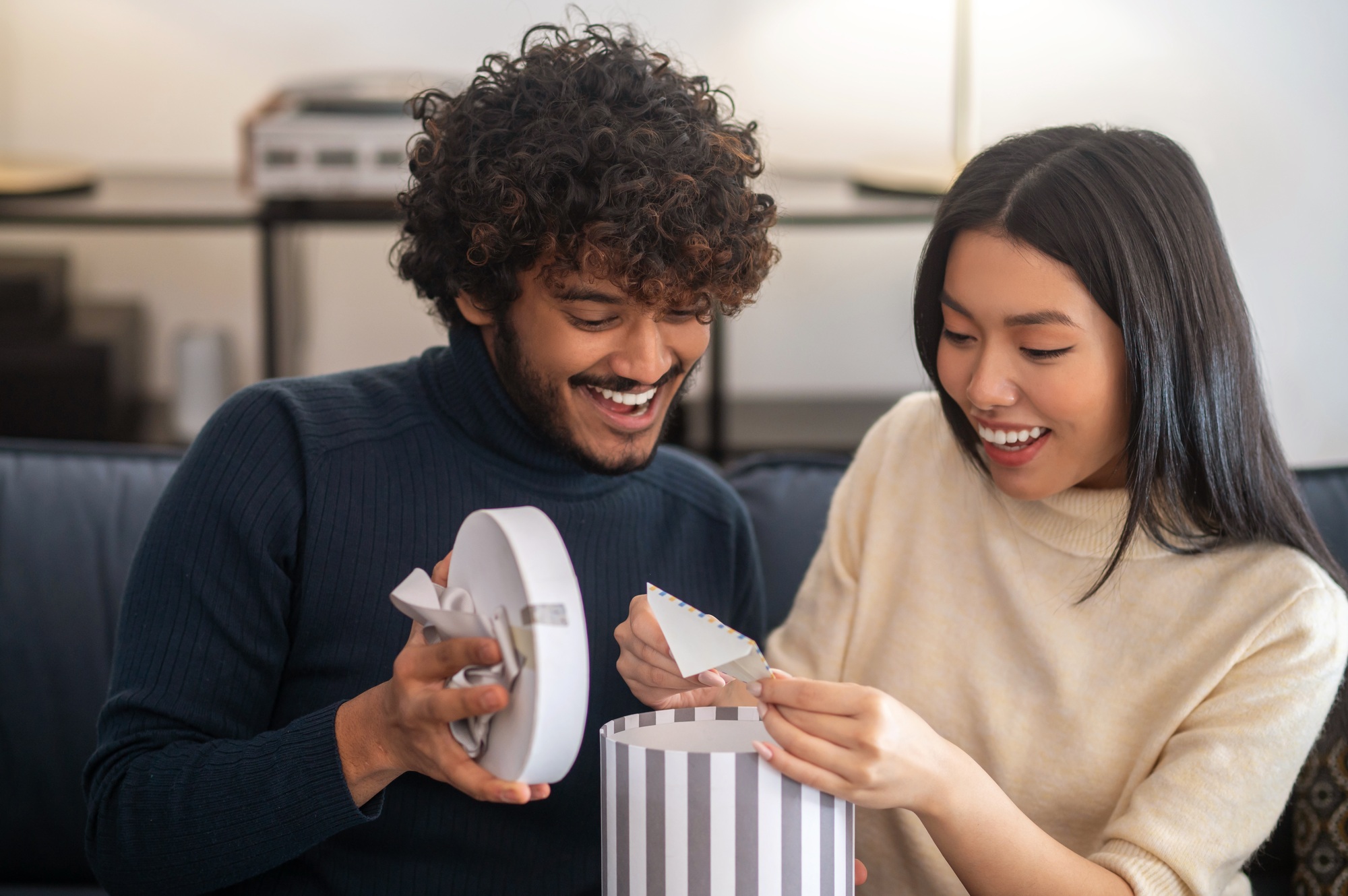 Man opening box and woman taking out letter