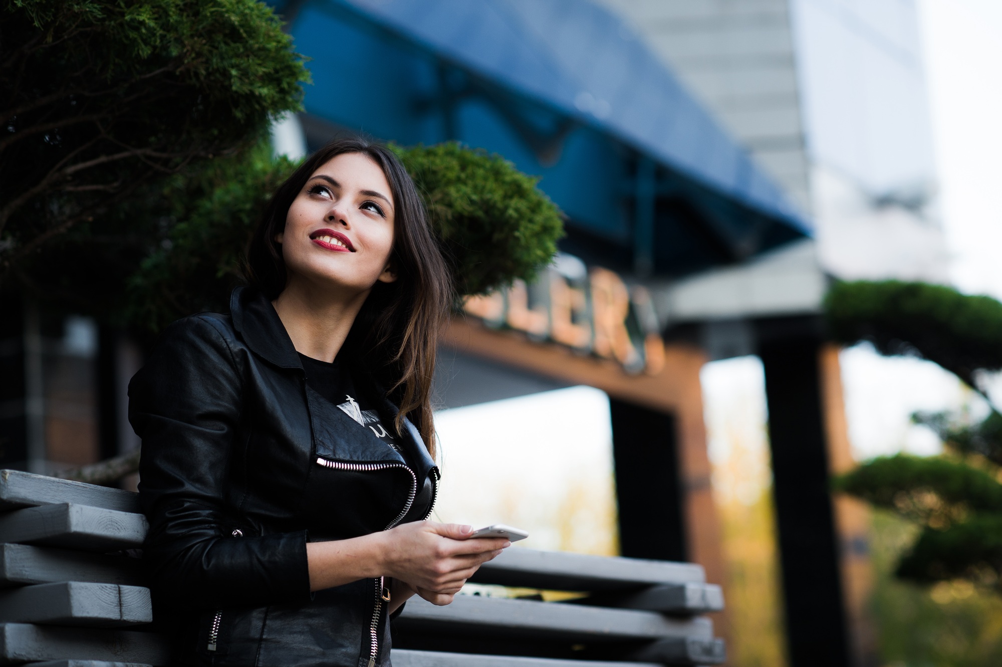 Smiling woman sending sms on the street