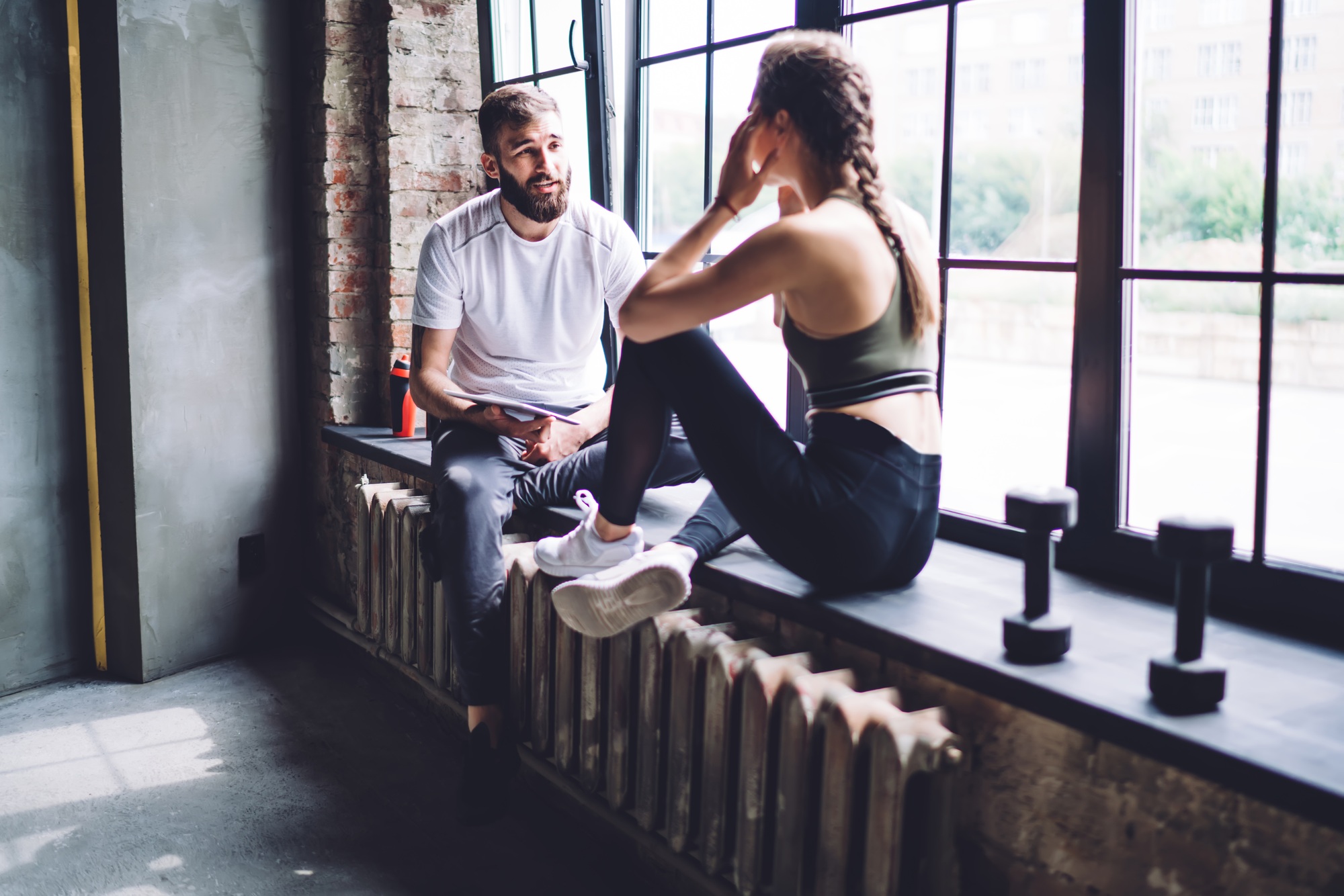 Woman asking questions her trainer during consultancy about losing weight and slimming